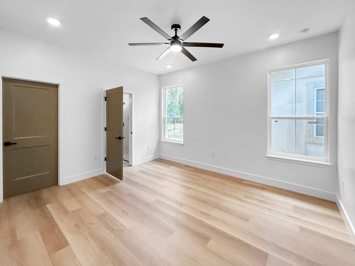 Primary bedroom at 1010 Hickory Avenue Sanford - ceiling fan, luxury vinyl floors, en suite access