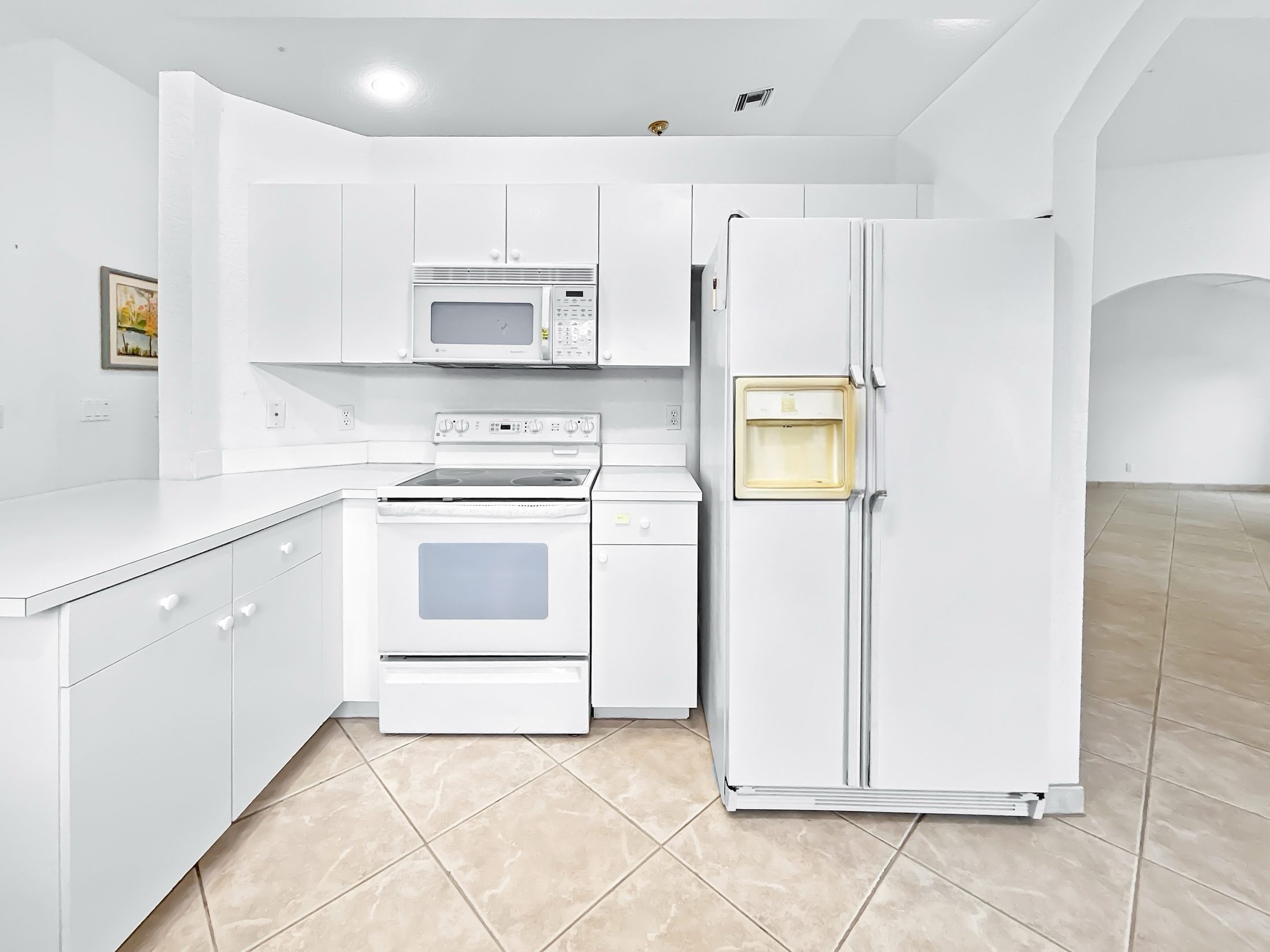 7880 Laina Lane #3 — kitchen with white cabinetry and appliances