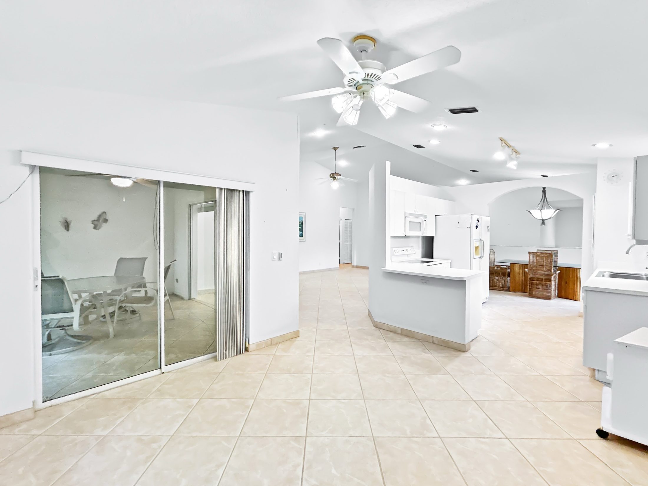 7880 Laina Lane #3 — open living area with sliding doors to screened balcony